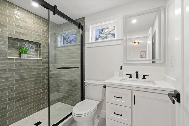 a bathroom with a toilet sink vanity and mirror