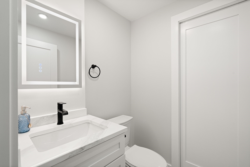 35 Dewey Street, Unit 35 Boston, MA 02125 - Photo 27 of 30 a bathroom with a sink a toilet and a mirror