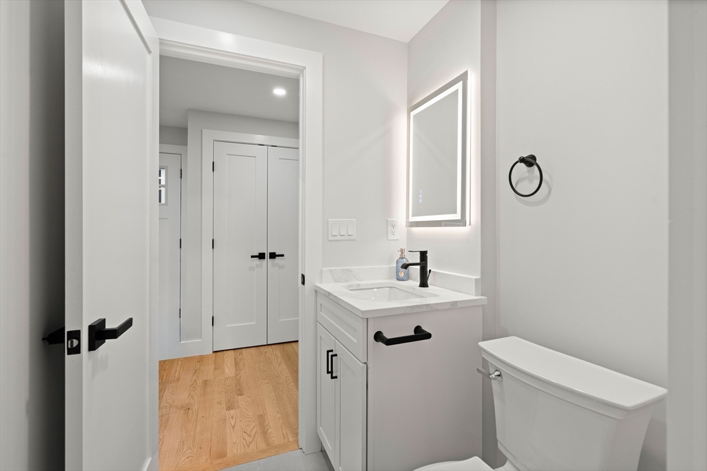 35 Dewey Street, Unit 35 Boston, MA 02125 - Photo 29 of 30 a bathroom with a toilet sink vanity and mirror
