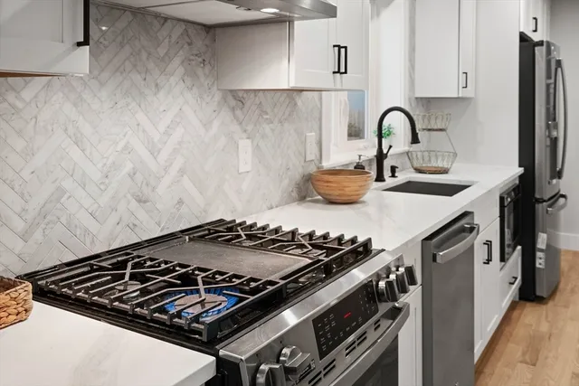 a stove top oven sitting inside of a kitchen