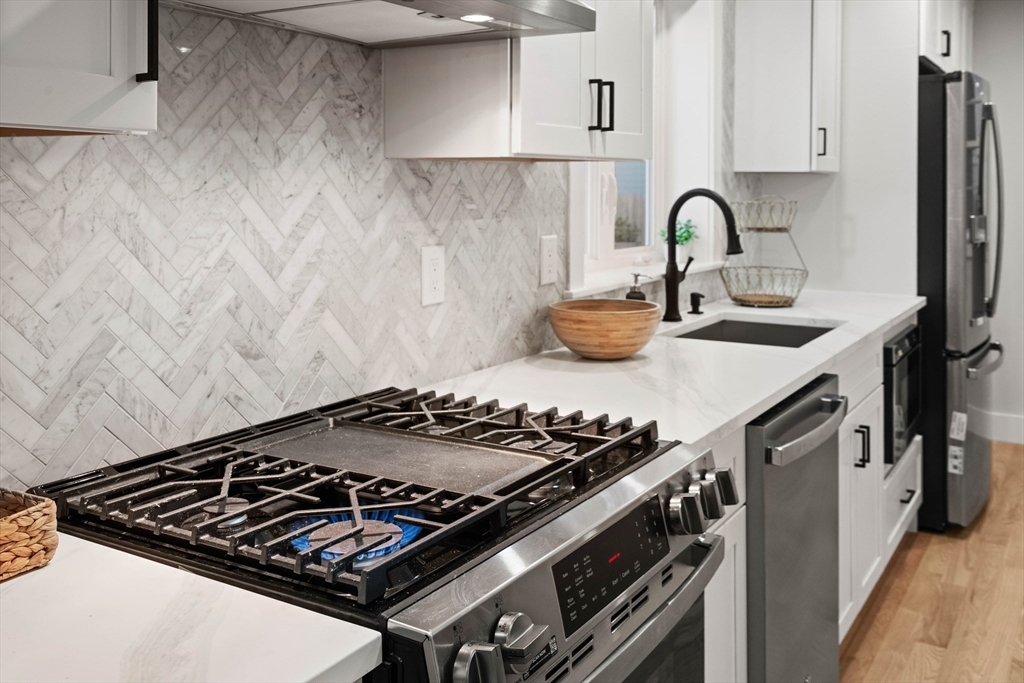 35 Dewey Street, Unit 35 Boston, MA 02125 - Photo 7 of 30 a stove top oven sitting inside of a kitchen
