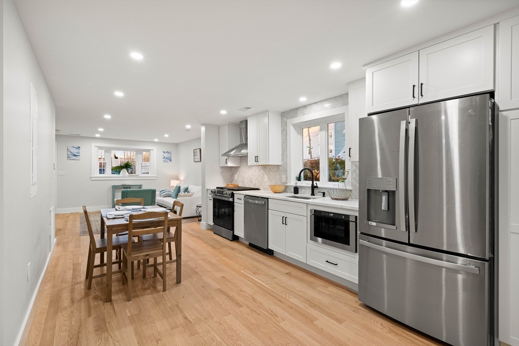 35 Dewey Street, Unit 35 Boston, MA 02125 - Photo 8 of 30 a kitchen with stainless steel appliances a refrigerator a stove a dining table and chairs
