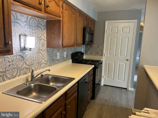 a kitchen with a sink stove top oven and cabinets