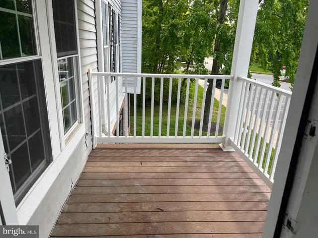 a view of balcony with wooden floor and fence