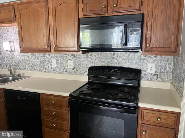 a kitchen with stainless steel appliances granite countertop white cabinets and a stove top oven