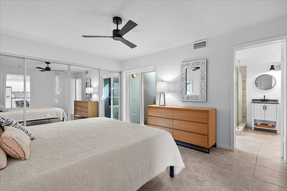 1605 Highway 1, Unit 7C Jupiter, FL 33477 - Photo 15 of 31 a bedroom with a bed a mirror and a chandelier