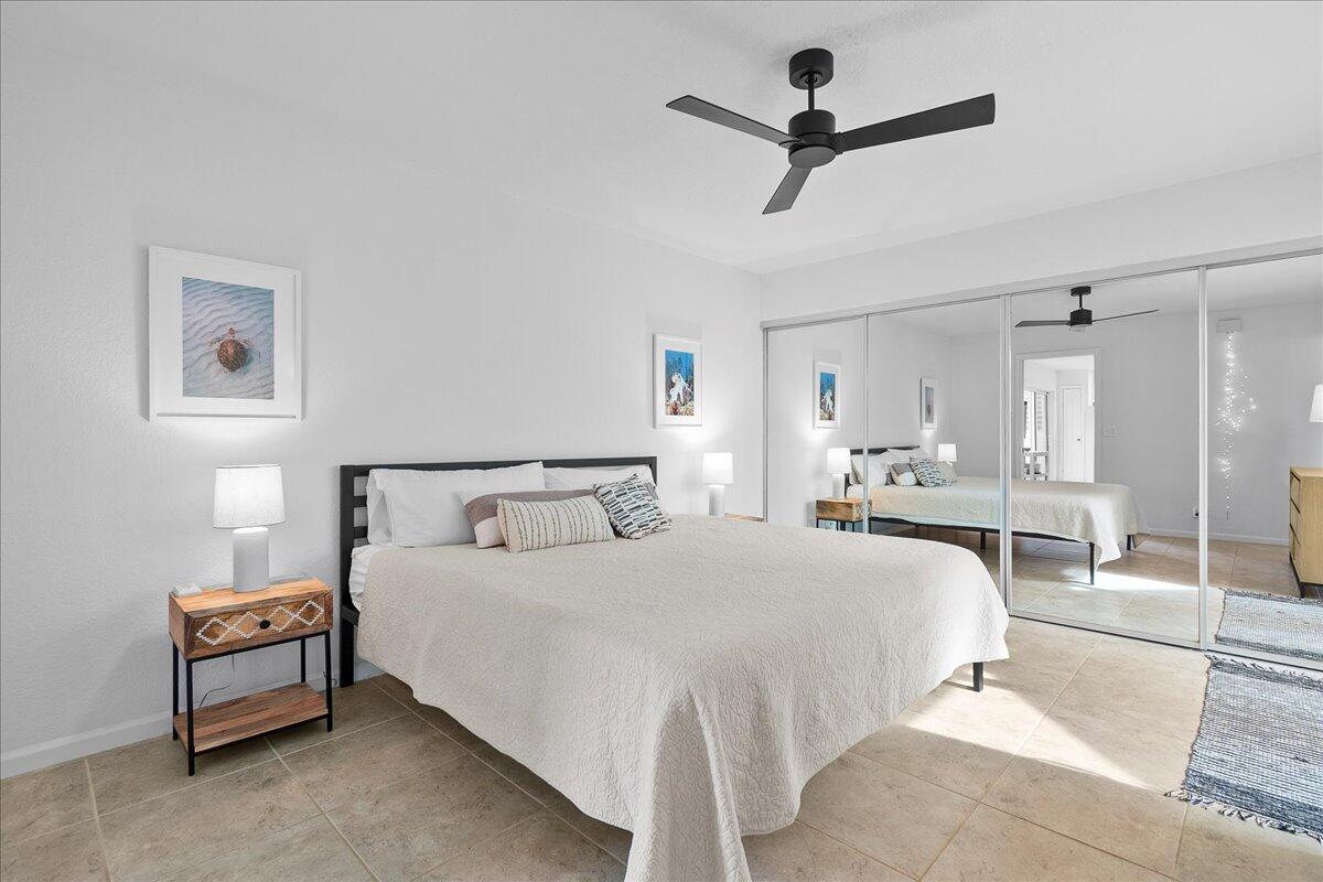 1605 Highway 1, Unit 7C Jupiter, FL 33477 - Photo 16 of 31 a bedroom with a bed and a chandelier