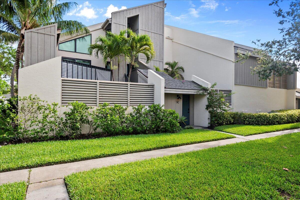 1605 Highway 1, Unit 7C Jupiter, FL 33477 - Photo 2 of 31 a front view of a house with a yard