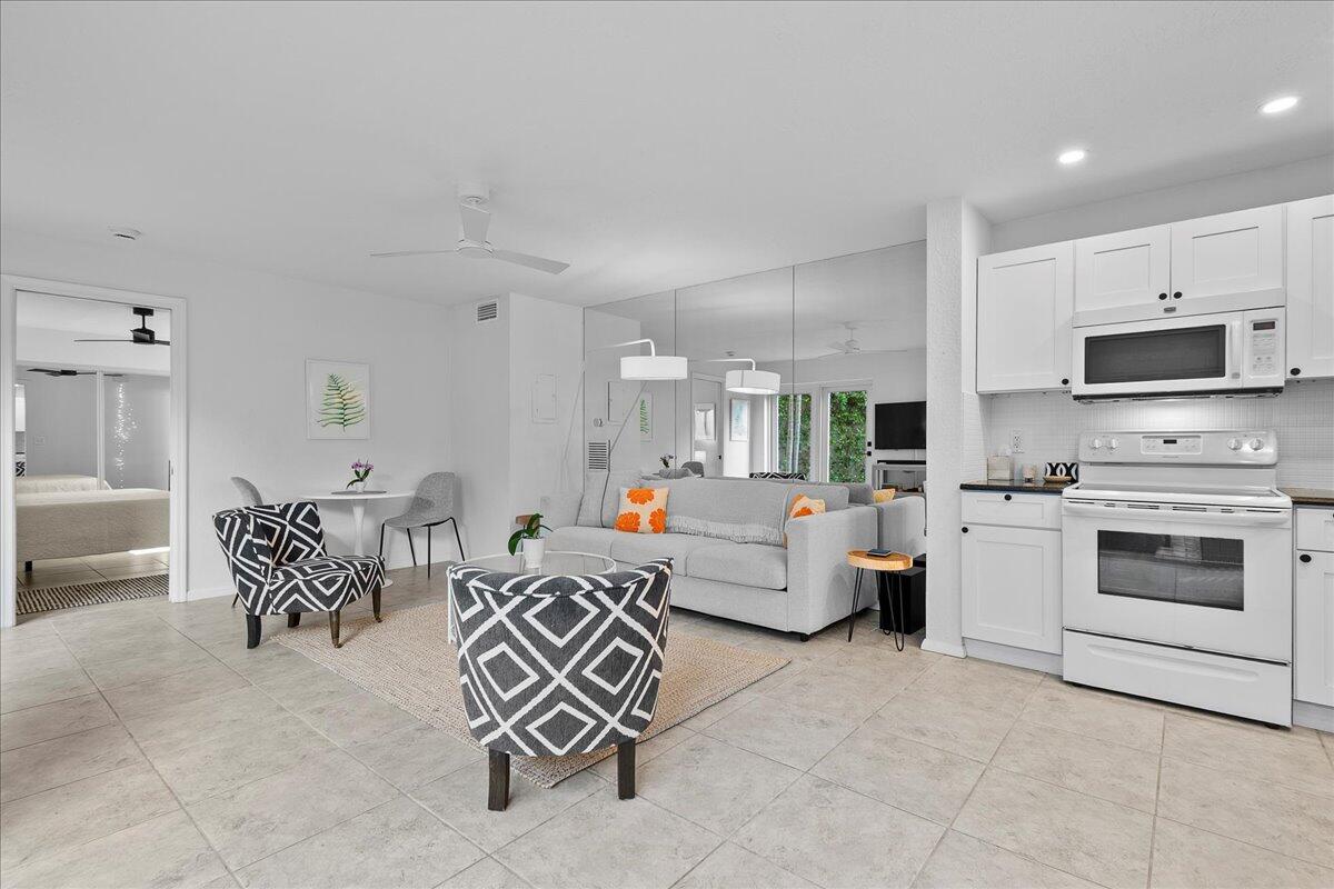 1605 Highway 1, Unit 7C Jupiter, FL 33477 - Photo 7 of 31 a kitchen with stainless steel appliances a stove a sink a microwave a dining table and chairs