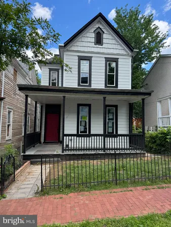 a front view of a house with a garden and plants