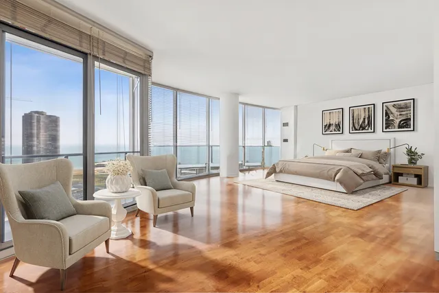 a spacious bedroom with a bed a couch and a view of en suite bathroom