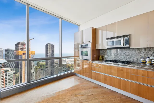 a kitchen with stainless steel appliances granite countertop a refrigerator a stove and a wooden cabinets