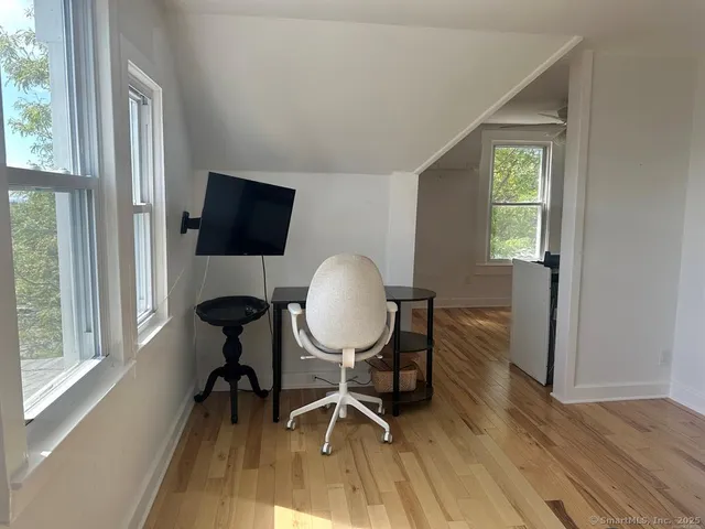 a view of a workspace with furniture and a window