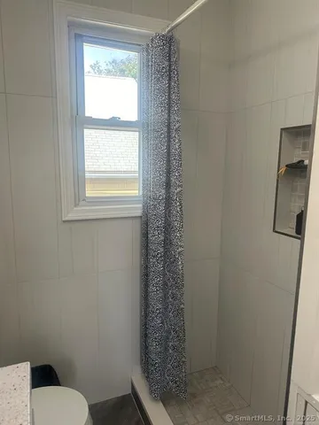 a bathroom with a toilet and a shower