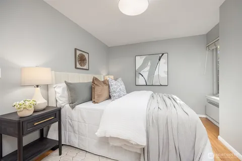 a bedroom with a bed and a lamp on dresser