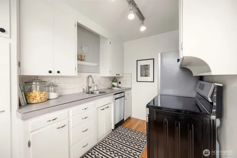 a kitchen with granite countertop a sink stainless steel appliances and cabinets