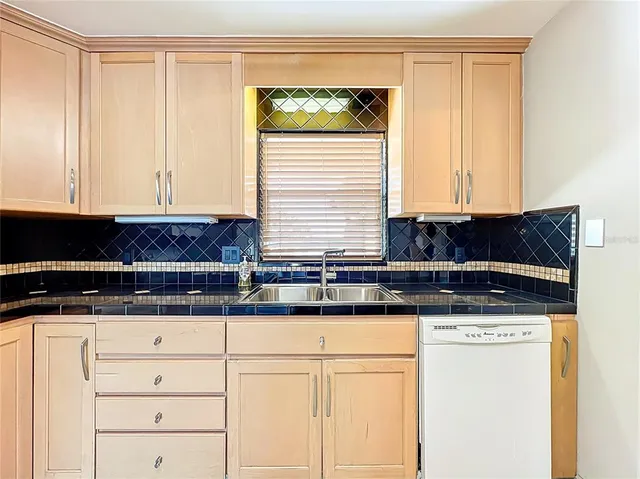 a kitchen with granite countertop a sink and a stove