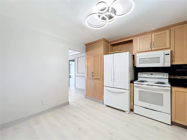 a kitchen with a refrigerator a stove top oven a cabinetry and kitchen island