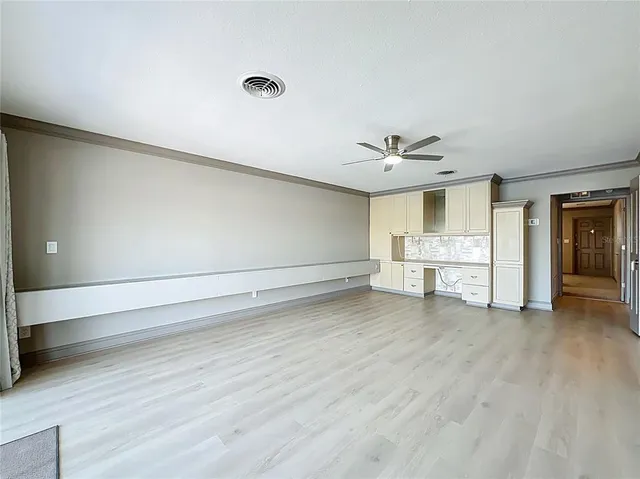 a view of a livingroom with wooden floor and a ceiling fan
