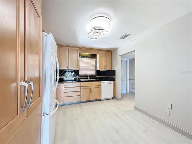 a kitchen with stainless steel appliances granite countertop a refrigerator and a stove