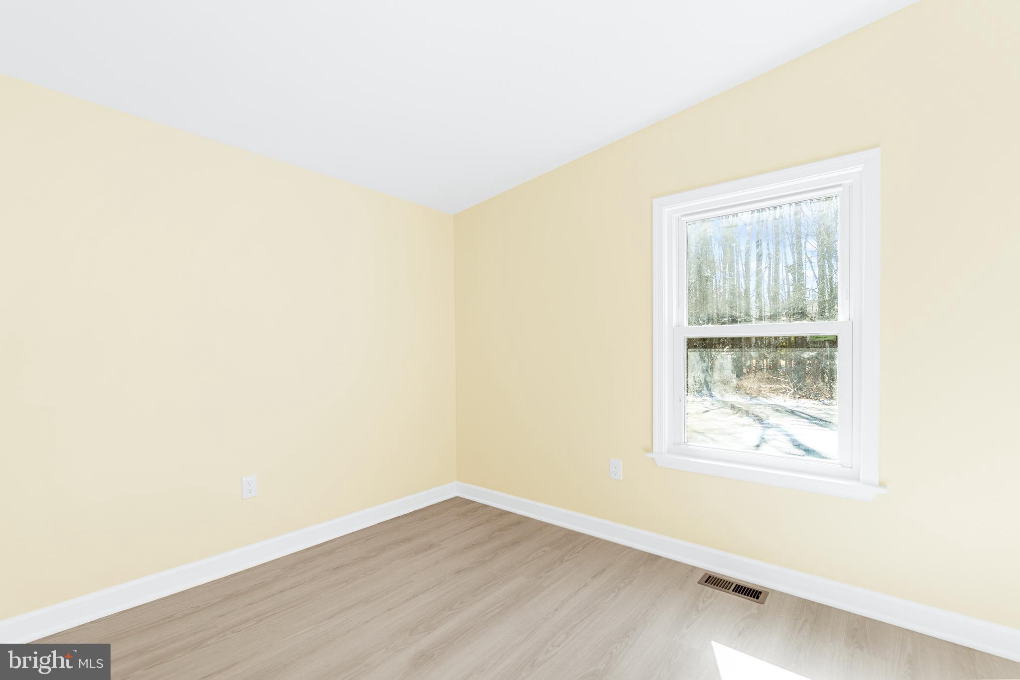 1349 Yorktown Road Annapolis, MD 21409 - Photo 19 of 35 a view of an empty room with wooden floor and a window