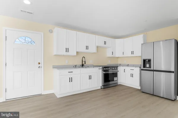 a kitchen with granite countertop white cabinets and white appliances