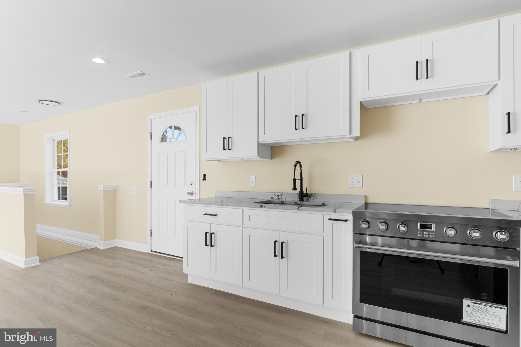 1349 Yorktown Road Annapolis, MD 21409 - Photo 25 of 35 a kitchen with granite countertop a stove sink and cabinets