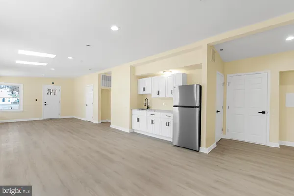 a view of a kitchen with refrigerator and wooden floor