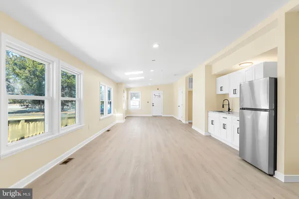 a view of an empty room with window and wooden floor