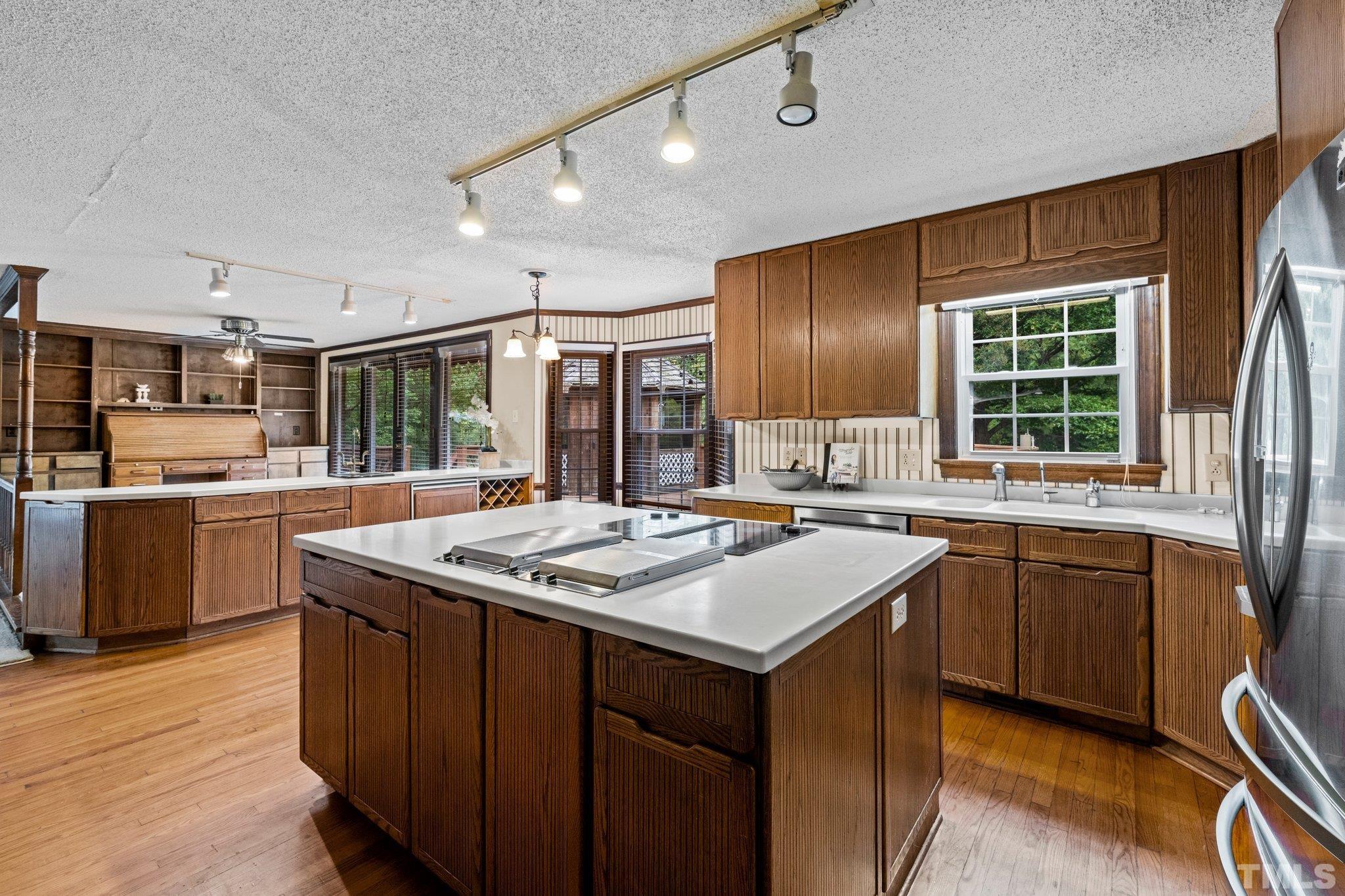 7525 South Tanglewild Drive Raleigh, NC 27613 - Photo 21 of 50 a kitchen with kitchen island granite countertop a sink stove and cabinets