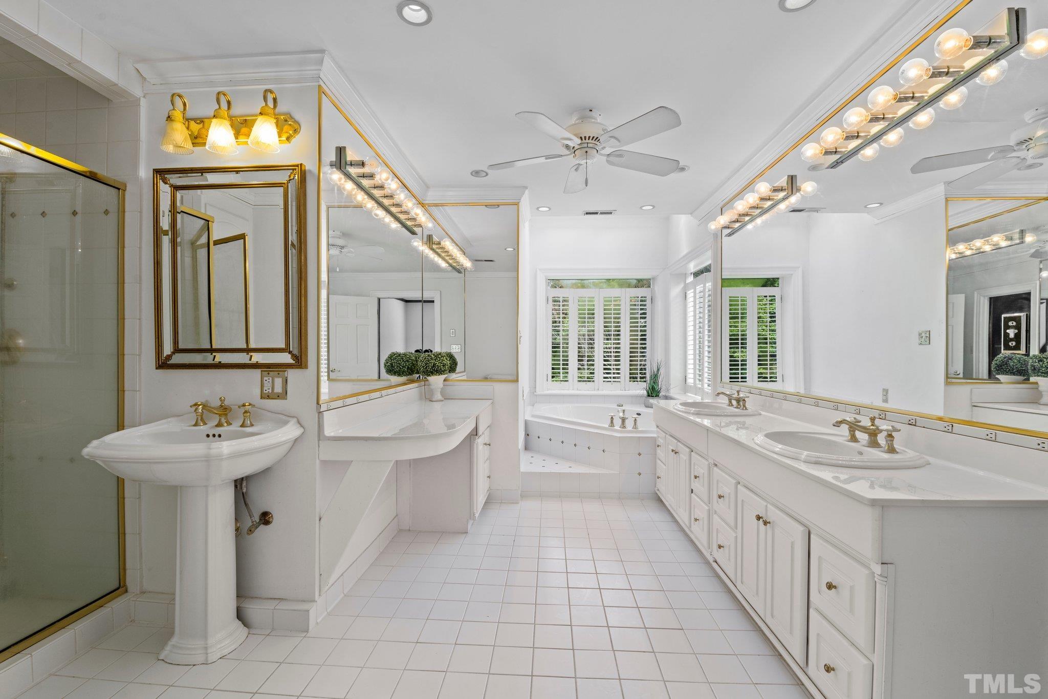 7525 South Tanglewild Drive Raleigh, NC 27613 - Photo 30 of 50 a bathroom with a double vanity sink a mirror and a bathtub