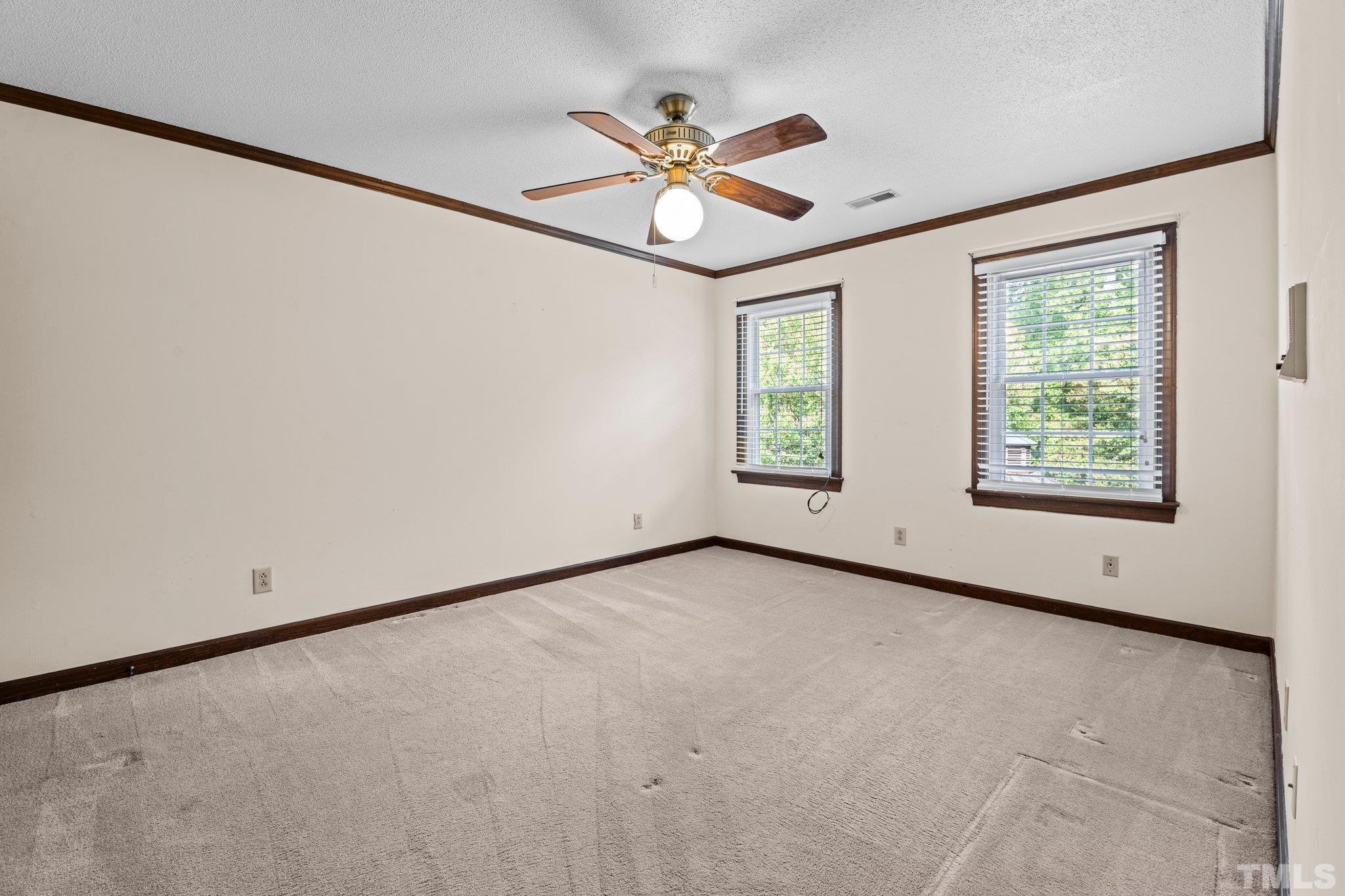 7525 South Tanglewild Drive Raleigh, NC 27613 - Photo 31 of 50 an empty room with window and ceiling fan