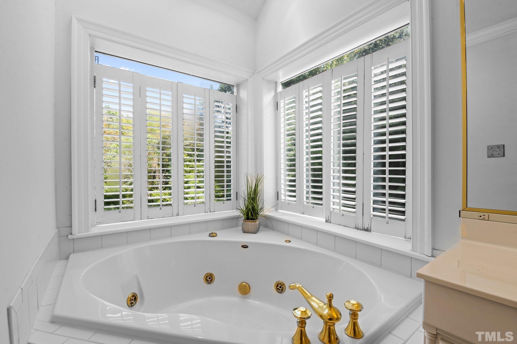 7525 South Tanglewild Drive Raleigh, NC 27613 - Photo 32 of 50 a white bath tub sitting in a bathroom next to a window
