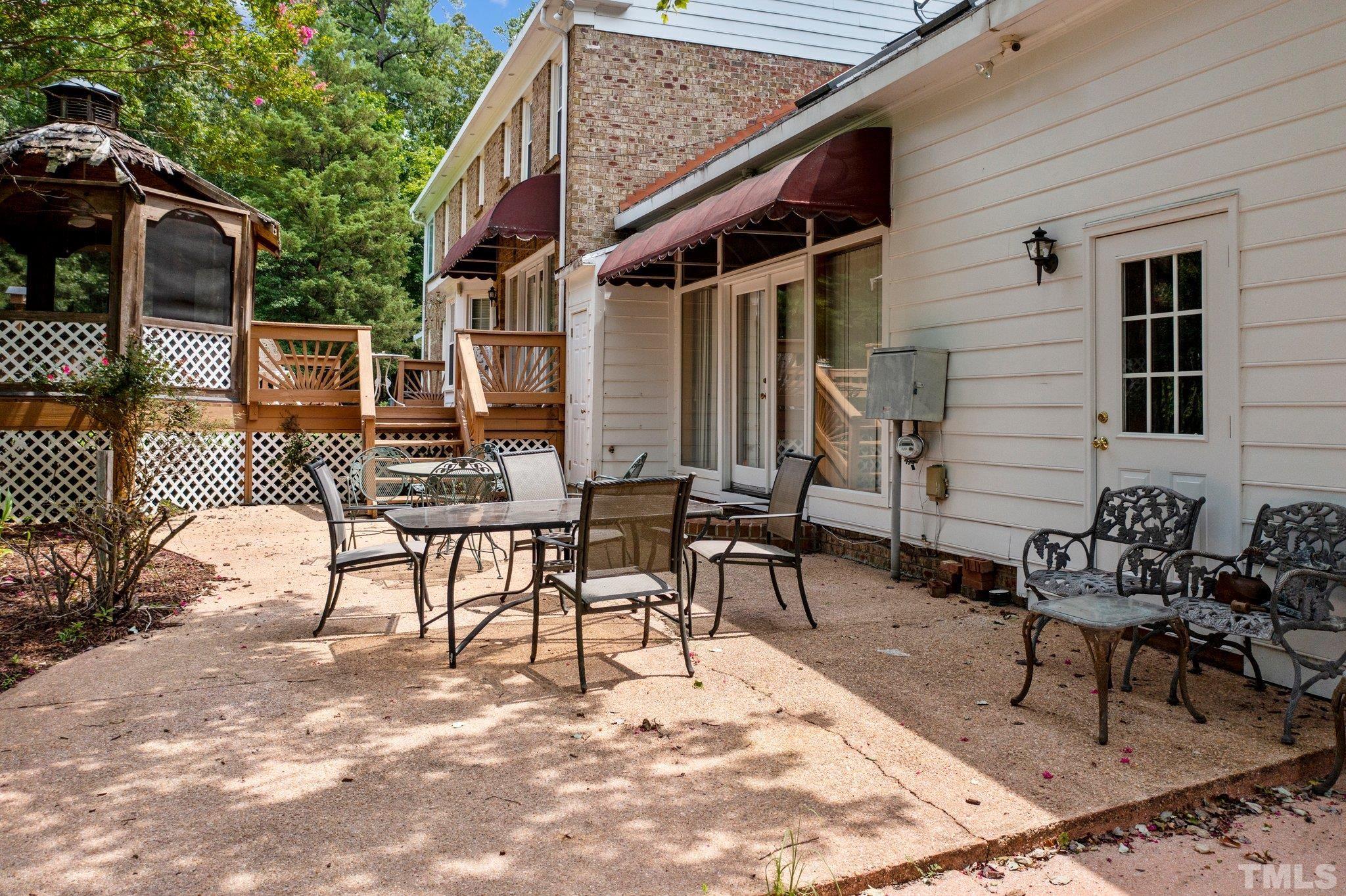 7525 South Tanglewild Drive Raleigh, NC 27613 - Photo 39 of 50 a view of a patio with a table and chairs in patio