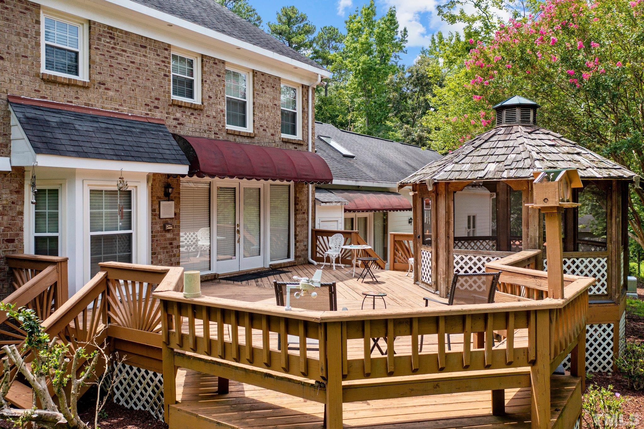 7525 South Tanglewild Drive Raleigh, NC 27613 - Photo 42 of 50 a roof deck with a table and chairs under an umbrella
