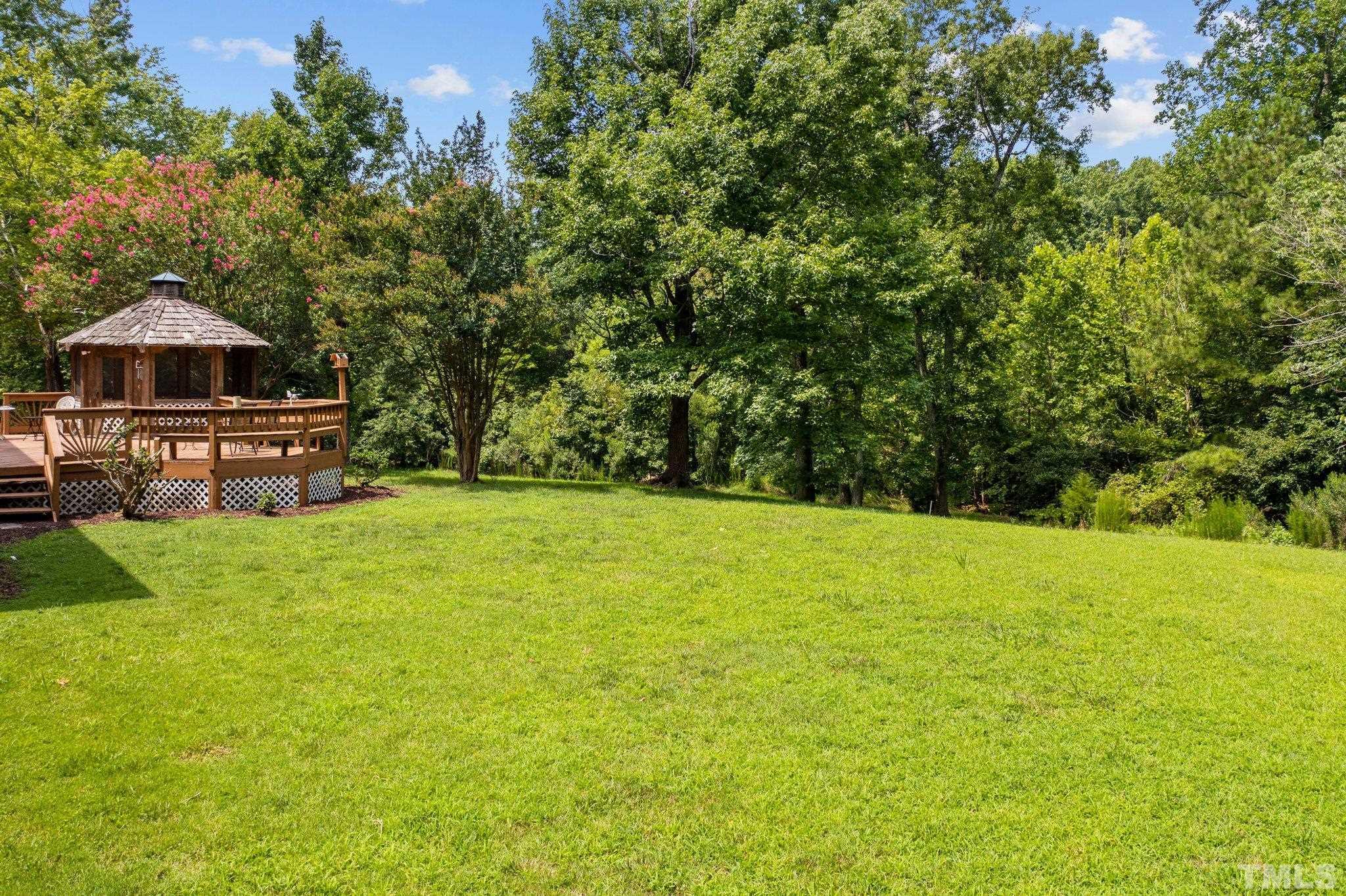 7525 South Tanglewild Drive Raleigh, NC 27613 - Photo 43 of 50 a backyard of a house with lots of green space