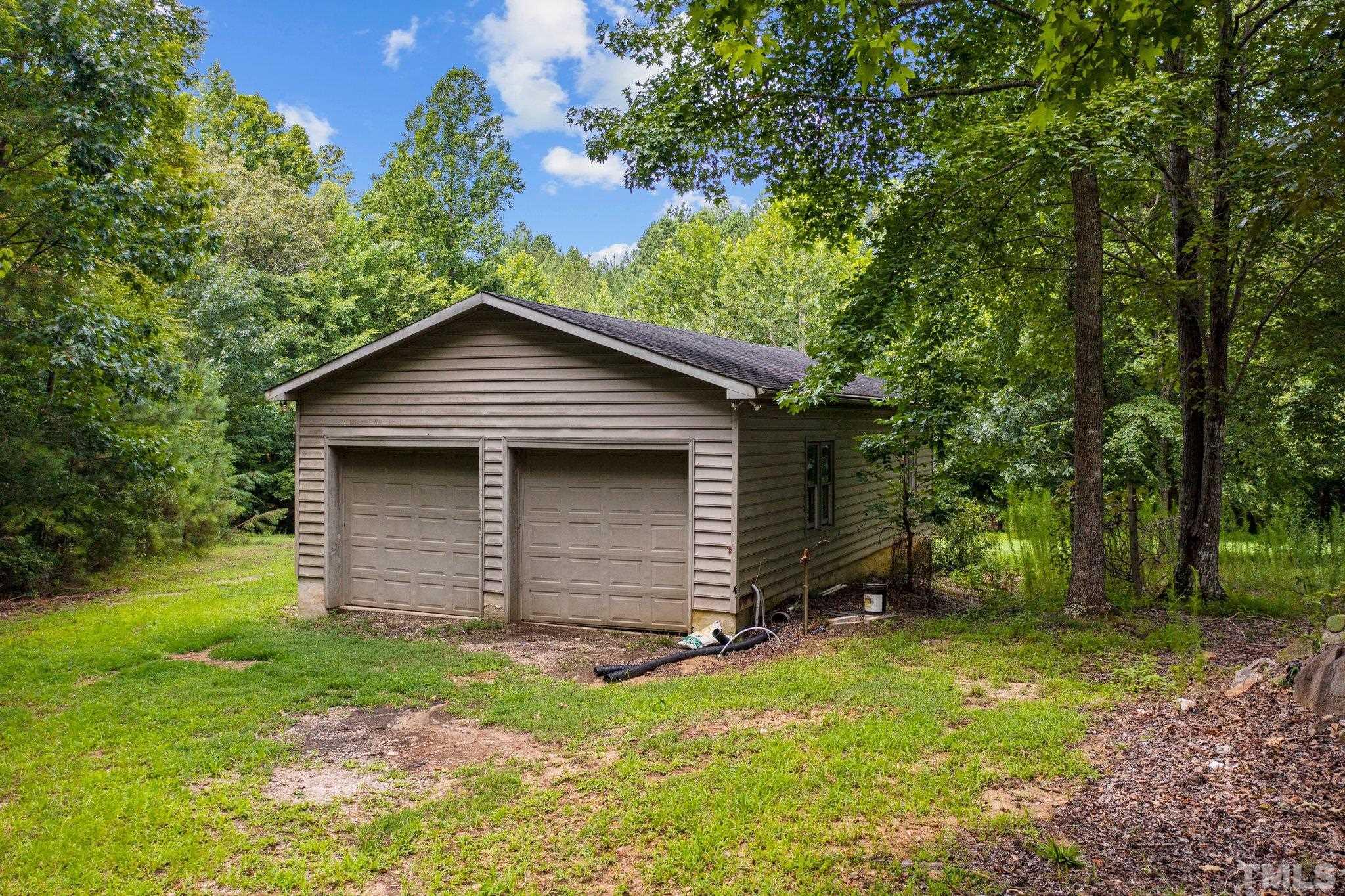 7525 South Tanglewild Drive Raleigh, NC 27613 - Photo 44 of 50 a view of a small house with a yard