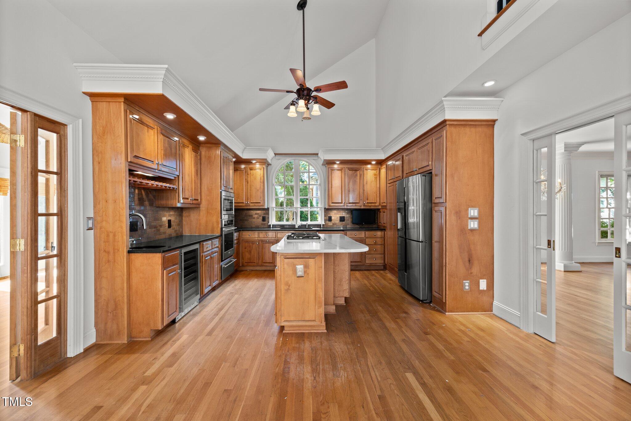 3604 Eden Croft Drive Raleigh, NC 27612 - Photo 11 of 49 a large kitchen with stainless steel appliances granite countertop a refrigerator a stove a sink dishwasher a dining table and chairs with wooden floor