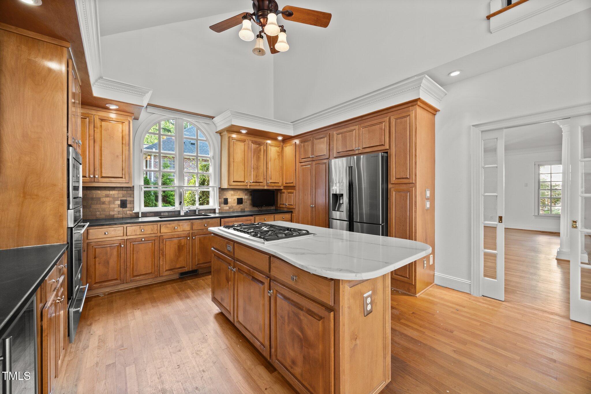 3604 Eden Croft Drive Raleigh, NC 27612 - Photo 12 of 49 a kitchen with stainless steel appliances granite countertop a refrigerator a sink dishwasher a stove and a dining table with wooden floor