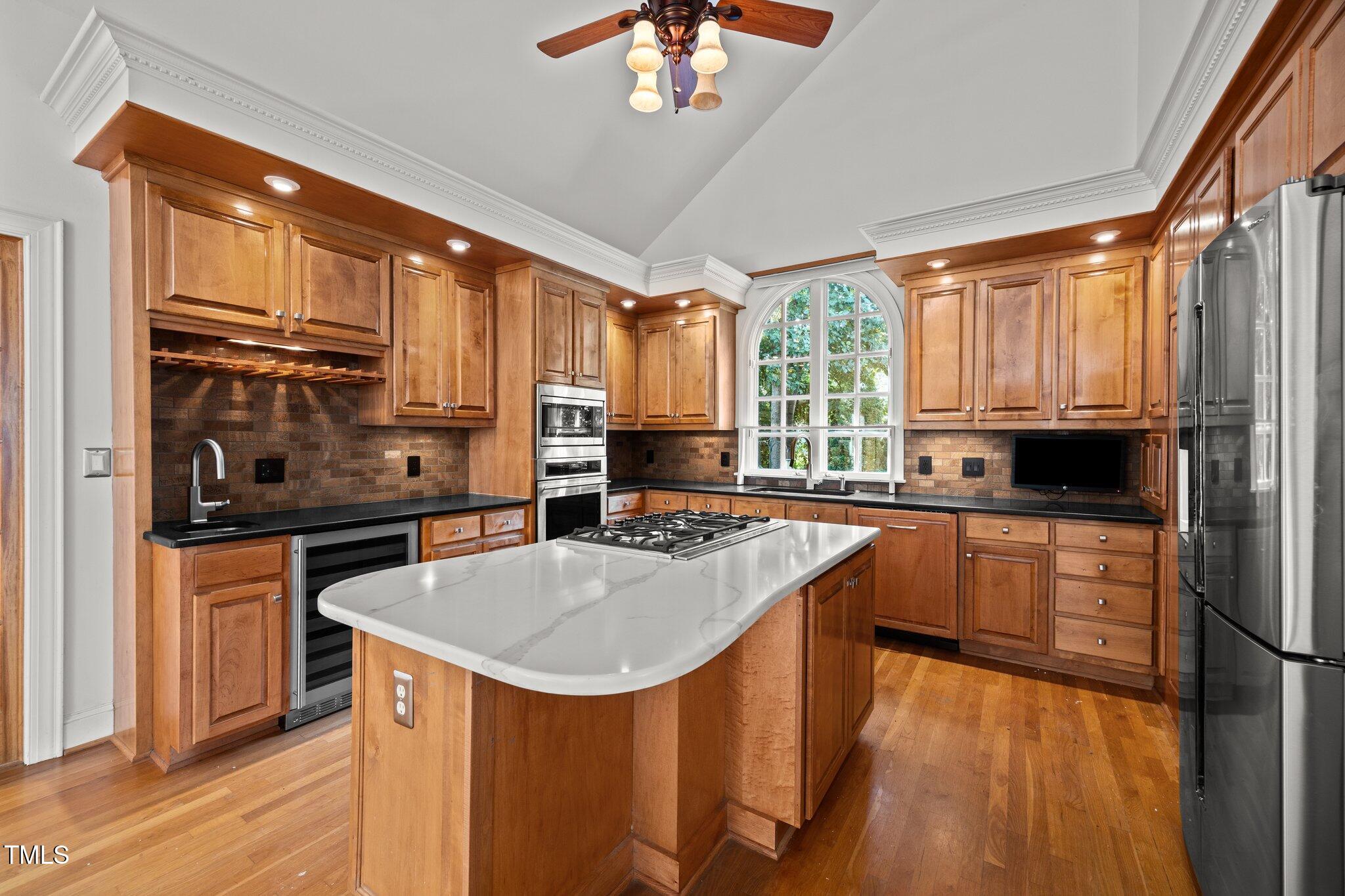 3604 Eden Croft Drive Raleigh, NC 27612 - Photo 13 of 49 a kitchen with kitchen island granite countertop a stove a sink and a refrigerator