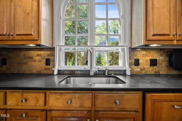 a kitchen with granite countertop a sink a counter space and windows