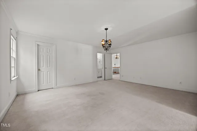 a view of empty room with a chandelier fan