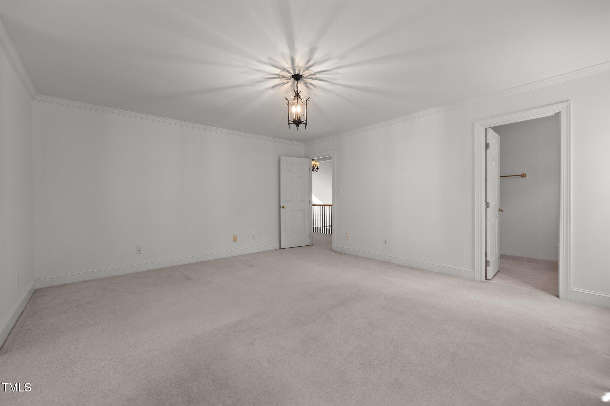 3604 Eden Croft Drive Raleigh, NC 27612 - Photo 39 of 49 an empty room with chandelier fan and windows