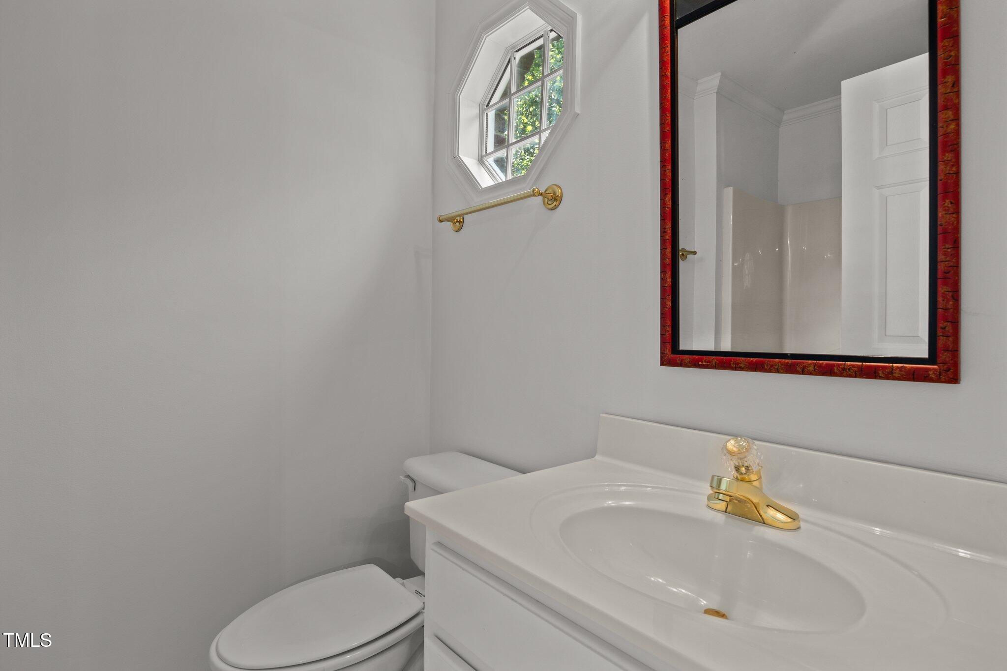3604 Eden Croft Drive Raleigh, NC 27612 - Photo 40 of 49 a bathroom with a toilet sink and mirror