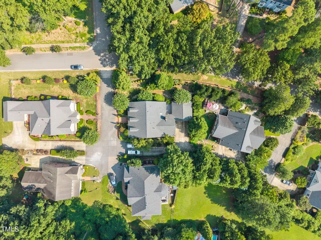 an aerial view of residential house with outdoor space and trees all around