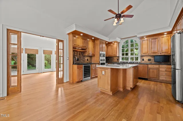 a large kitchen with lots of counter space a sink and stainless steel appliances