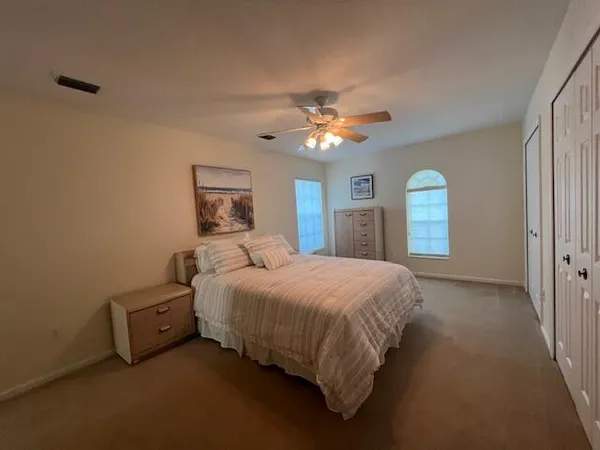 a spacious bedroom with a bed and a chandelier