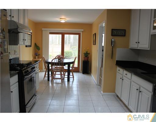 36 Huntington Road Edison, NJ 08820 - Photo 2 of 19 a kitchen with stainless steel appliances granite countertop a stove a refrigerator a dining table and chairs