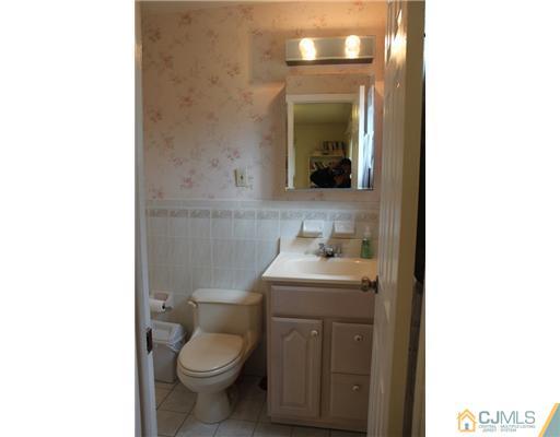 36 Huntington Road Edison, NJ 08820 - Photo 8 of 19 a bathroom with a toilet sink and mirror