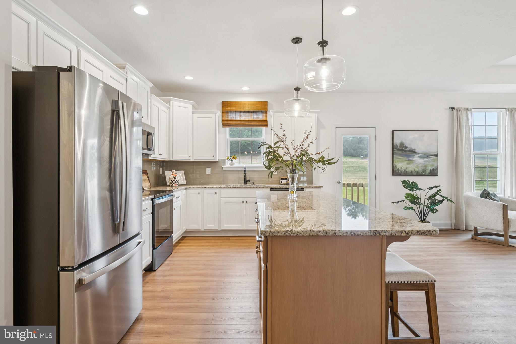 150 Piedmont Way, Unit 101 Hanover, PA 17331 - Photo 11 of 40 a kitchen with stainless steel appliances granite countertop a refrigerator a sink dishwasher a oven with white cabinets and wooden floor